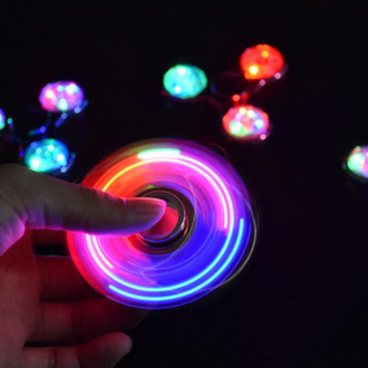 "Transparent LED fidget spinner med kristallklart material, blinkande lampor och snurrfunktion för stressavlastning."