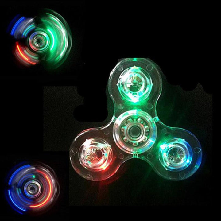 "Transparent LED fidget spinner med kristallklart material, blinkande lampor och snurrfunktion för stressavlastning."