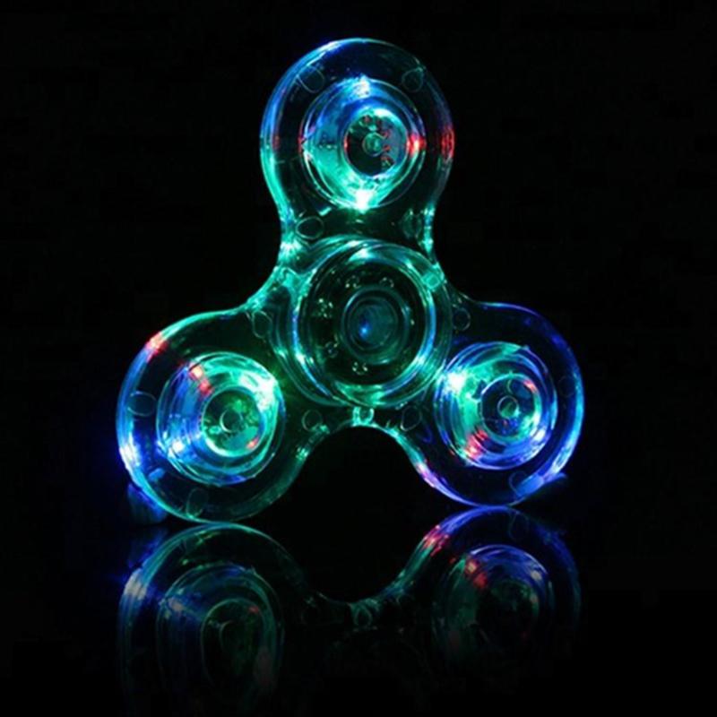 "Transparent LED fidget spinner med kristallklart material, blinkande lampor och snurrfunktion för stressavlastning."