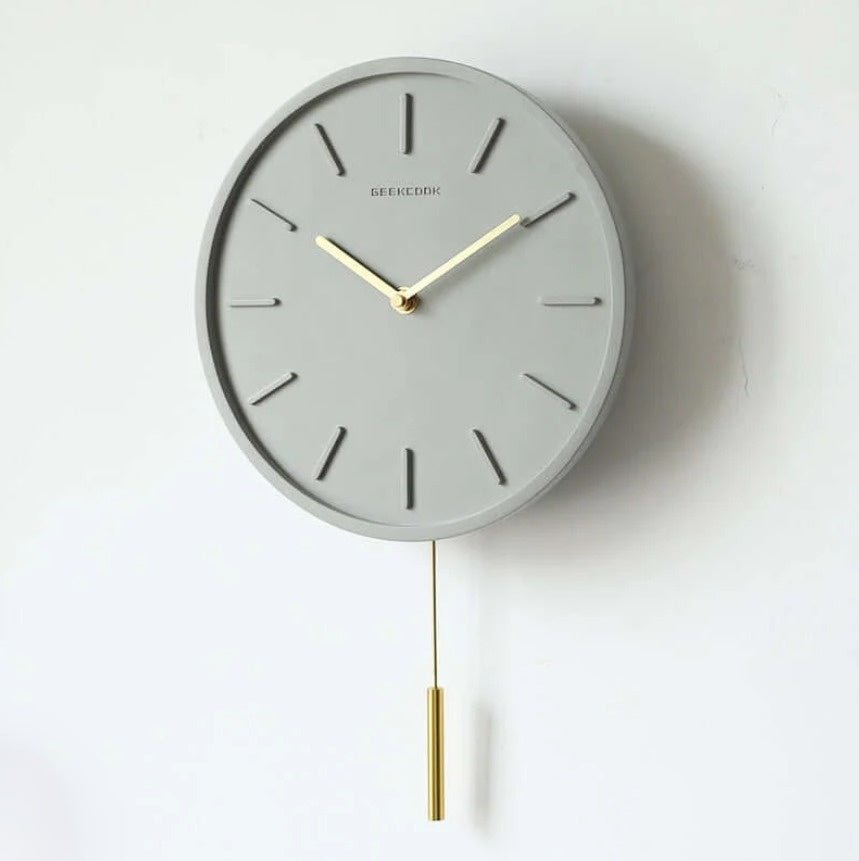 Stilren cementklocka med unik look, tystgående urverk och sofistikerad metallpendel. För en modern touch i hemmet.