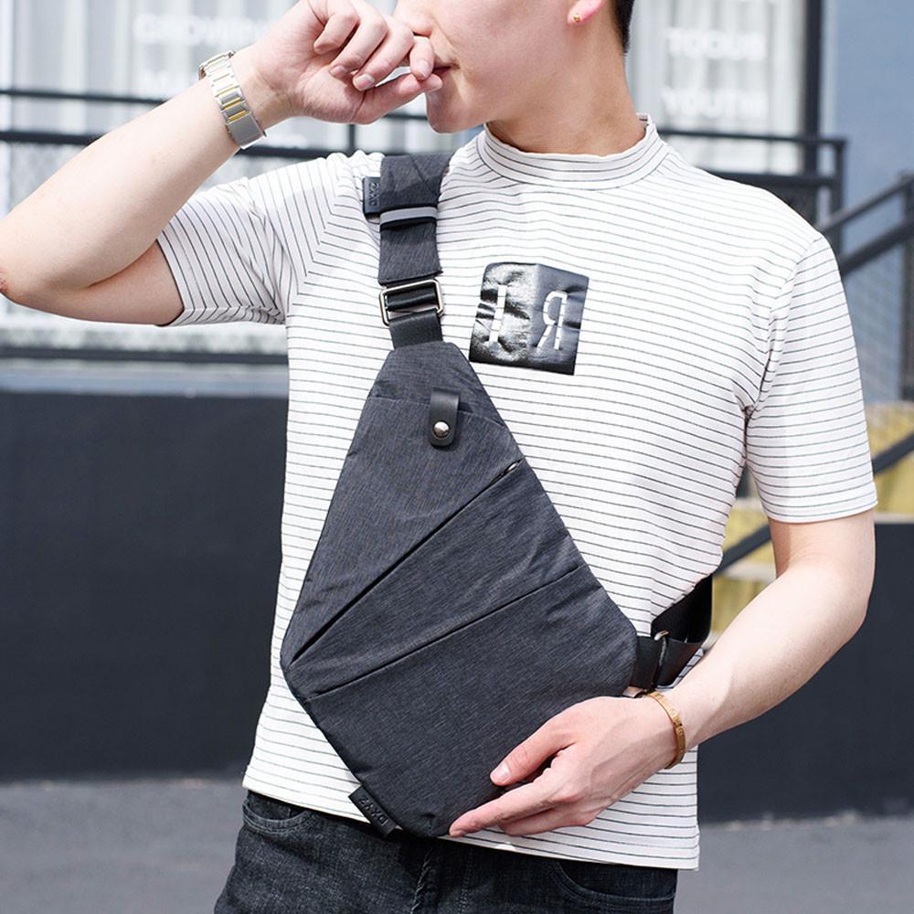 "Unisex axelväska i mörkgrå färg med justerbara remmar och flera fickor, elegant och funktionell designaccessoar."