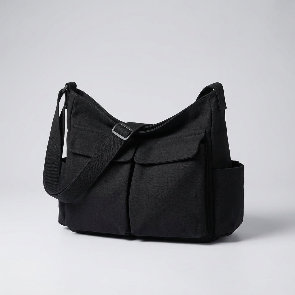 Praktisk canvas axelväska med justerbar rem, sedd från sidan. En idealisk unisex messenger väska.