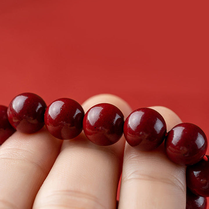Unisex cinnabar armband i röd jasper med släta pärlor, eleganta och jordande smycken för daglig användning.