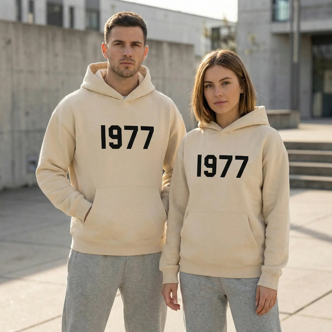 Unisex hoodie med raglanärmar och retro 1977-tryck. Perfekt streetwear luvtröja för en avslappnad stil.