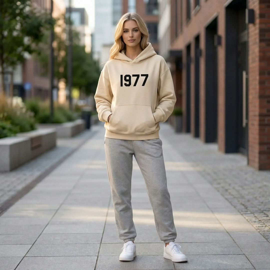 Avslappnad unisex hoodie med raglanärmar, perfekt för vinterkläder och streetwear mode. Med 1977-tryck.
