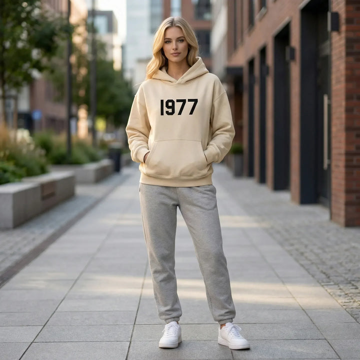 Avslappnad unisex hoodie med raglanärmar, perfekt för vinterkläder och streetwear mode. Med 1977-tryck.