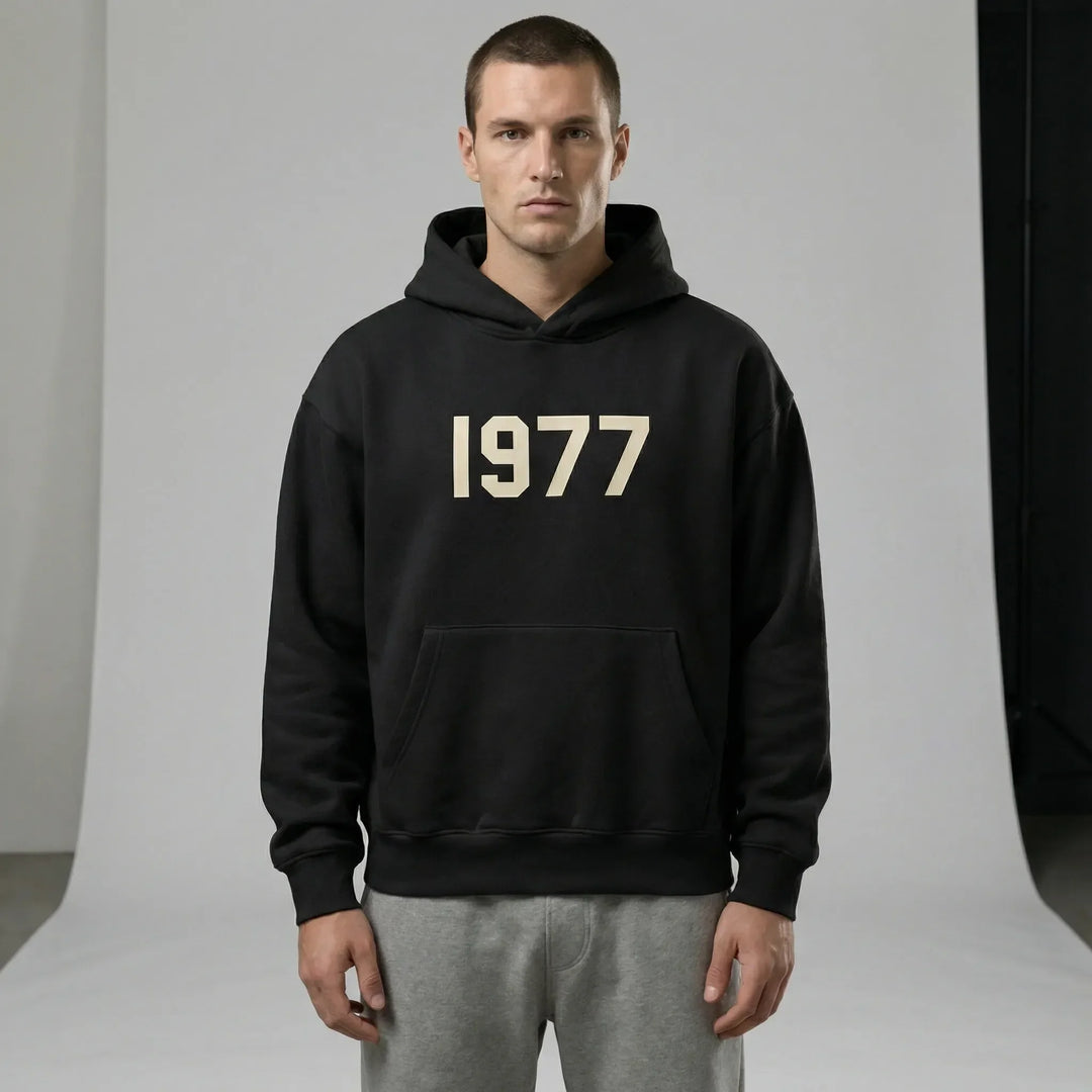 Mjuk unisex hoodie med raglanärmar, retro 1977-design. Perfekt luvtröja för avslappnad streetwear stil.