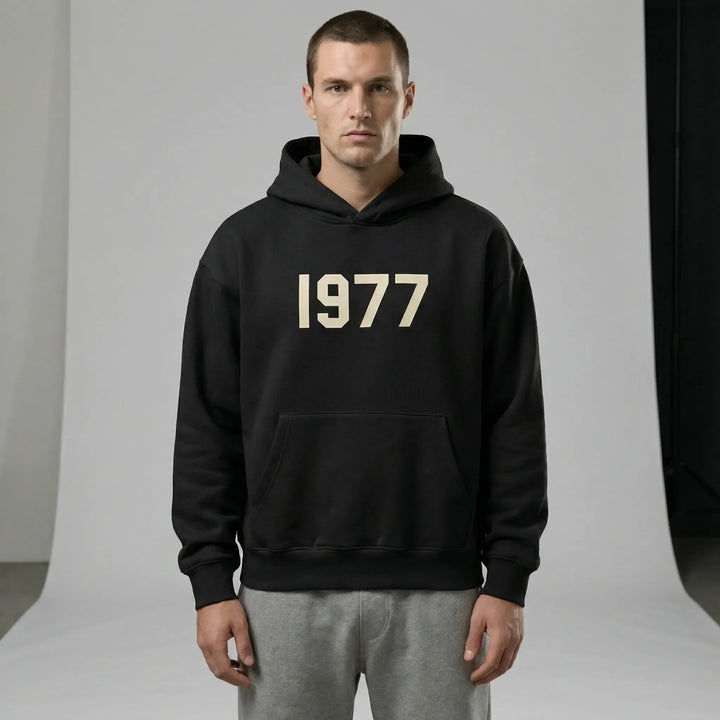 Mjuk unisex hoodie med raglanärmar, retro 1977-design. Perfekt luvtröja för avslappnad streetwear stil.