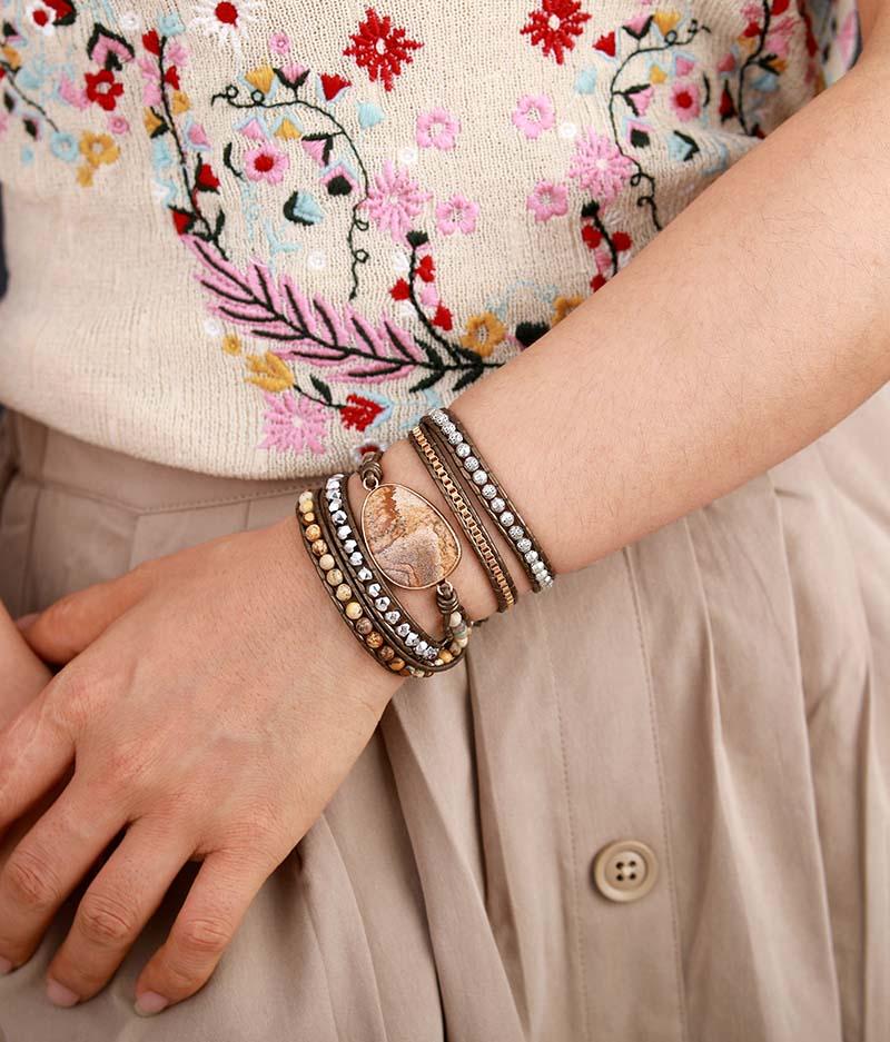 Jordande lindat armband med äkta naturstenar, handgjort i läder. Ett unisex smycke med healingeffekt.