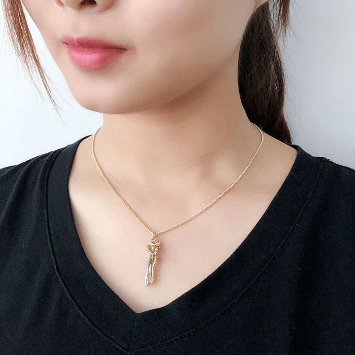 Elegant kramhalsband, minimalistiskt hängsmycke som symboliserar en kram, ett tidlöst kärlekssmycke.