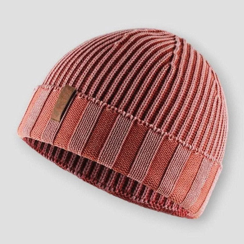 Man bär en mångsidig stickad mössa i retrostil, en modern accessoar för kalla dagar.