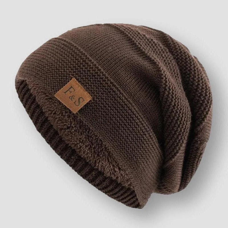 Svart stickad mössa med tjockt fleecefoder, en mångsidig huvudbonad för unisex användning.
