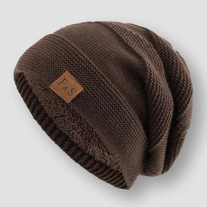 Svart stickad mössa med tjockt fleecefoder, en mångsidig huvudbonad för unisex användning.