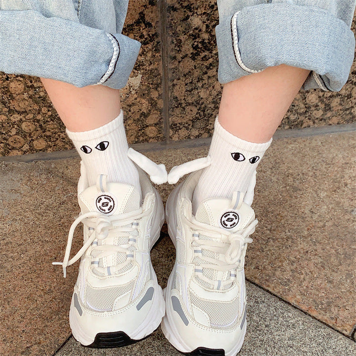 "Unisex strumpor i polyester med magnetiska händer i svart eller vitt, symboliserar kärlek och samhörighet, accessoar."