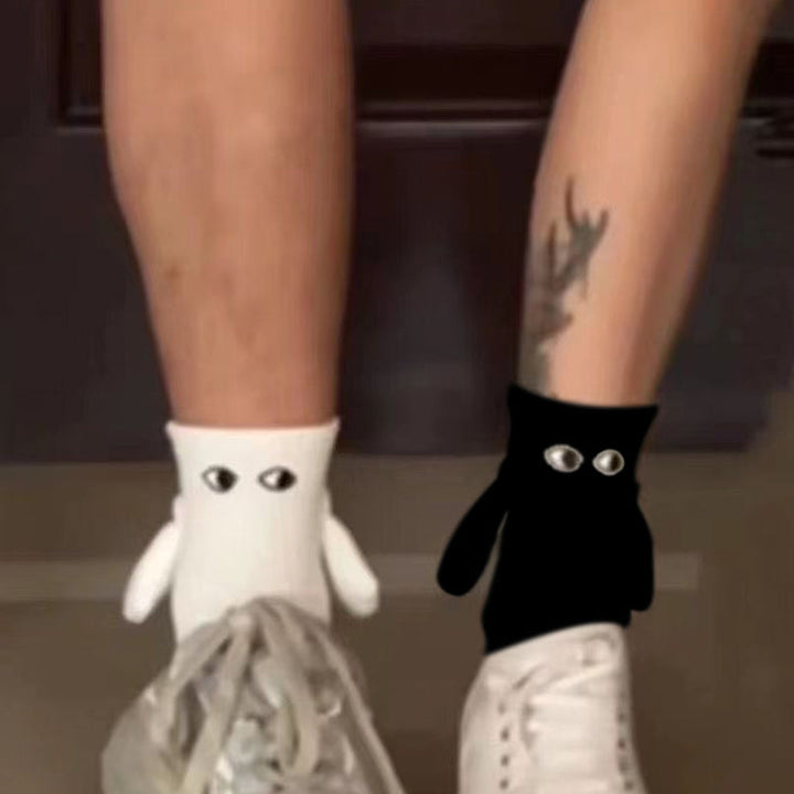 "Unisex strumpor i polyester med magnetiska händer i svart eller vitt, symboliserar kärlek och samhörighet, accessoar."