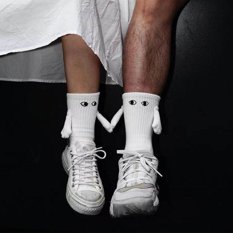 "Unisex strumpor i polyester med magnetiska händer i svart eller vitt, symboliserar kärlek och samhörighet, accessoar."