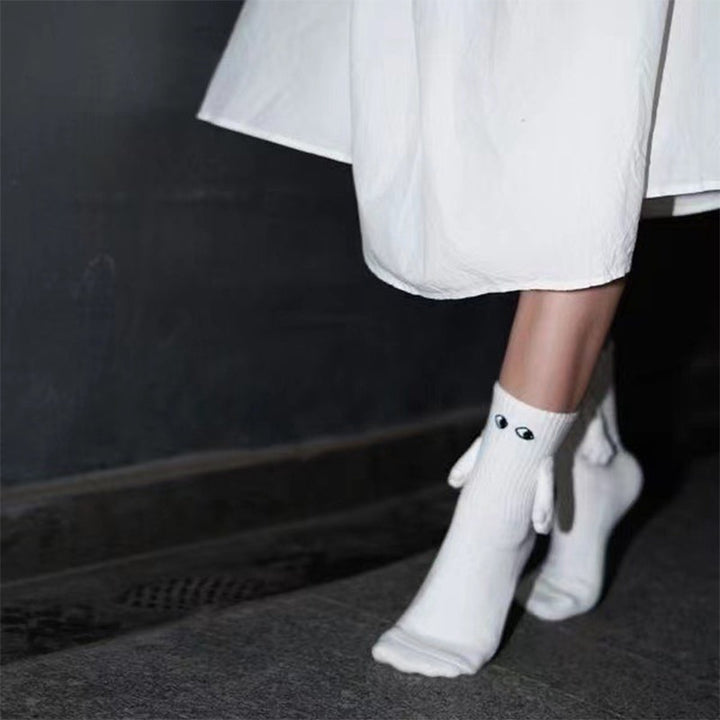 "Unisex strumpor i polyester med magnetiska händer i svart eller vitt, symboliserar kärlek och samhörighet, accessoar."