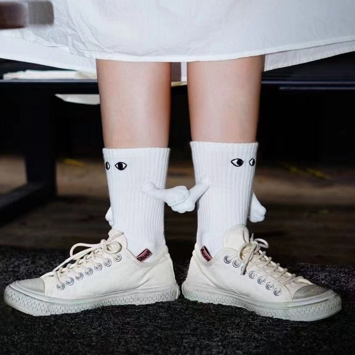 "Unisex strumpor i polyester med magnetiska händer i svart eller vitt, symboliserar kärlek och samhörighet, accessoar."