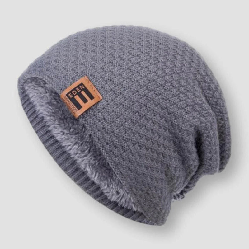 Närbild på en grå våffelstickad beanie med mjukt fleecefoder, en varm unisex vintermössa.