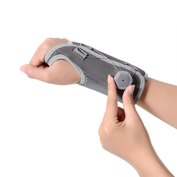 "Unisex vrist stödbandage i grå och svart för sport och träning, med justerbar passform och mikrofibertyg för stöd."
