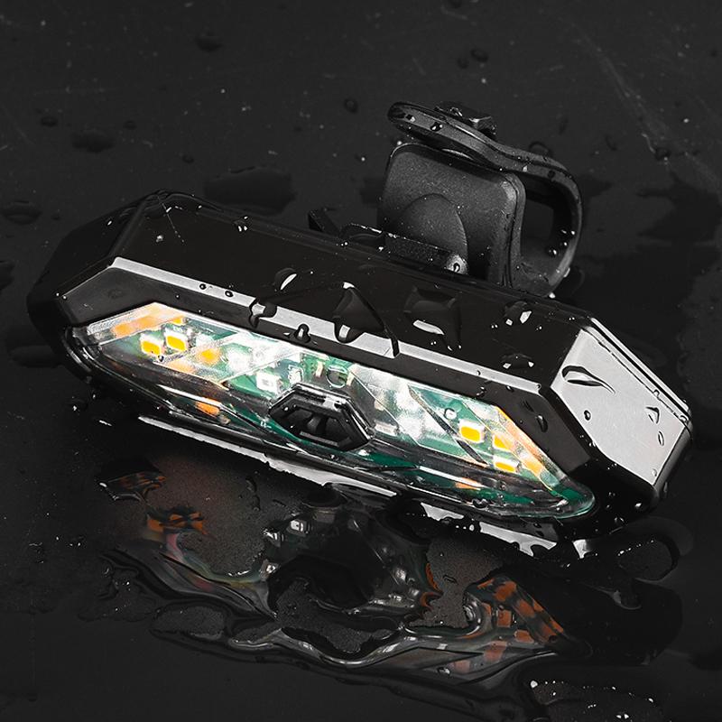 "USB-uppladdningsbart cykel bakljus med blinkers och horn, svart design, LED-ljus för säker cykling, vädertåligt."