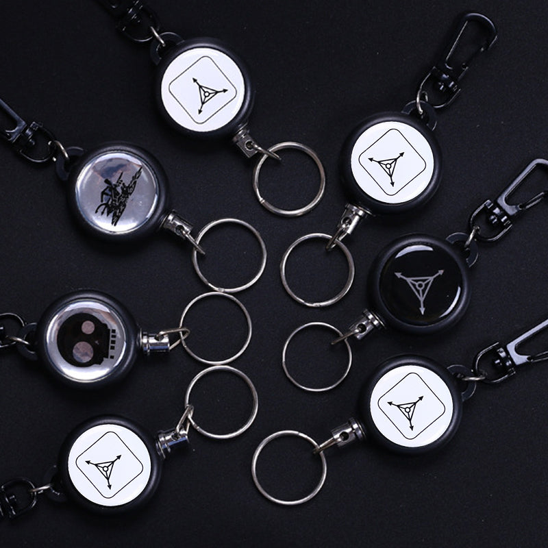 "Utdragbar nyckelring i metall med 60 cm stark stållina, perfekt för bälte eller ryggsäck. Slitstarkt och praktiskt tillbehör