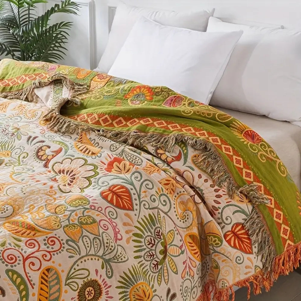 Mjuk bohemisk pläd med blommigt mönster. Vändbar design för mysiga stunder i hemmet.