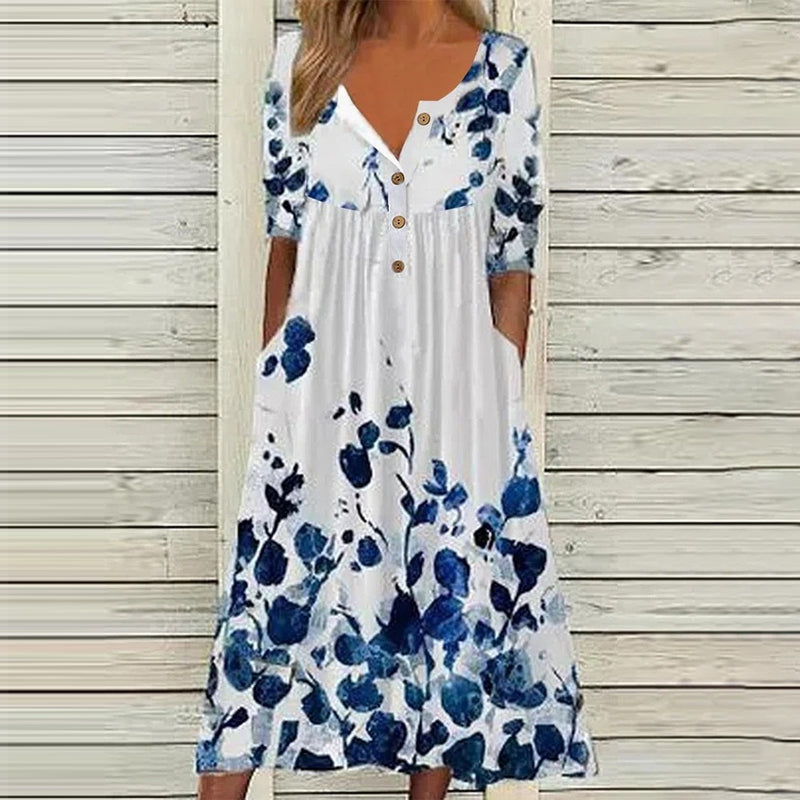 "V-ringad sommarklänning med blomtryck, elegant hög midja och flytande lång kjol, perfekt för soliga dagar."