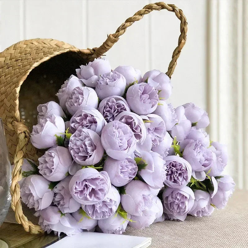 Detaljbild av en romantisk konstblomsterbukett med rosarosa och lila silkespioner.