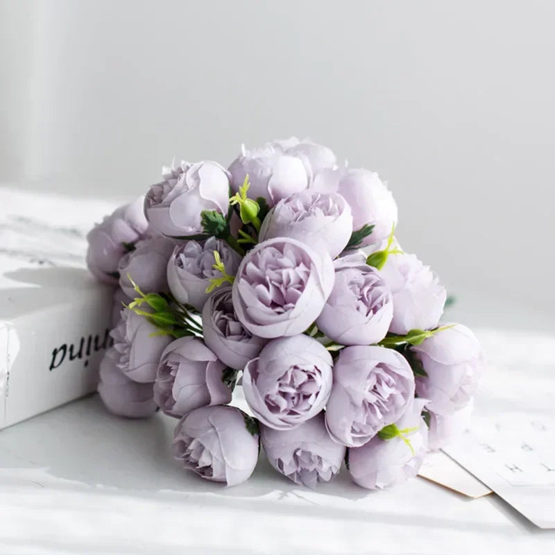 Närbild på realistiska silkesblommor, pioner i rosa och vita toner, perfekt som brudbukett.