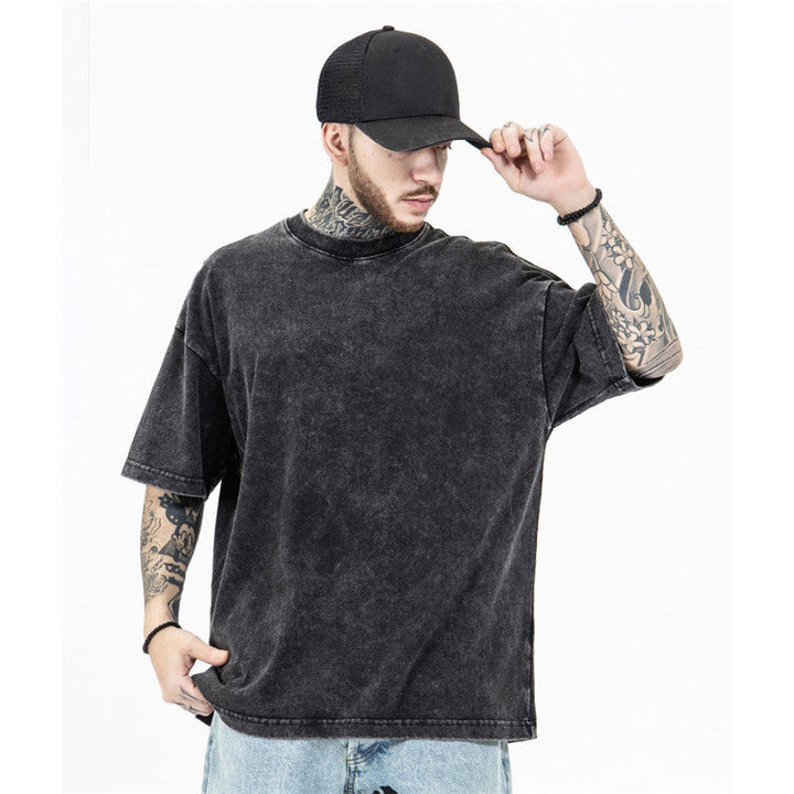 "Överdimensionerad lös T-shirt för män i svart bomull, visad framifrån med o-ringad krage, perfekt för avslappnad stil."