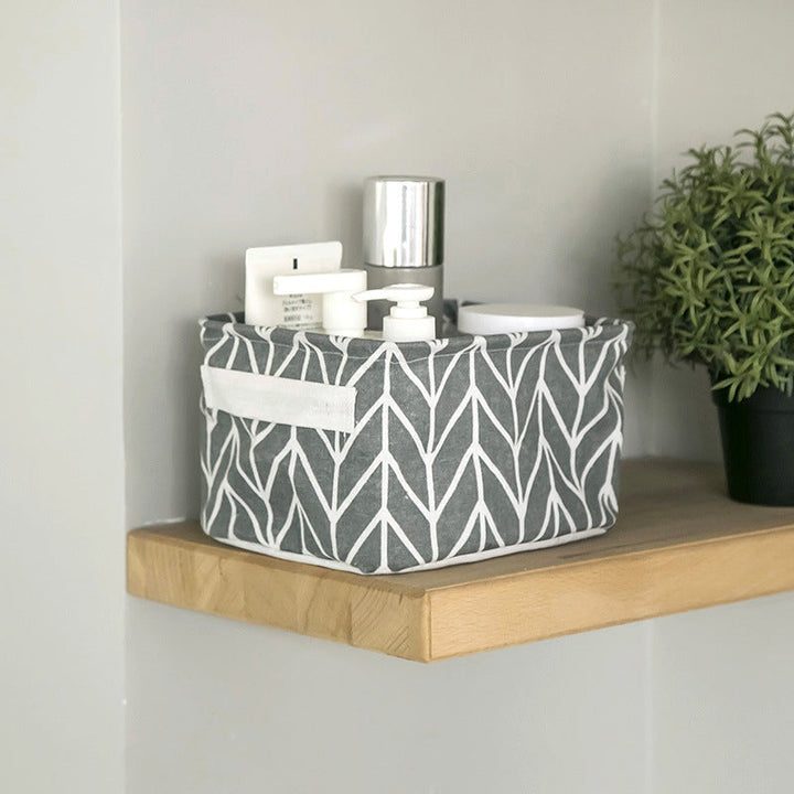 "Vikbar canvas förvaringslåda med tecknad design, i grått och vitt, perfekt för organisering av leksaker och kläder."