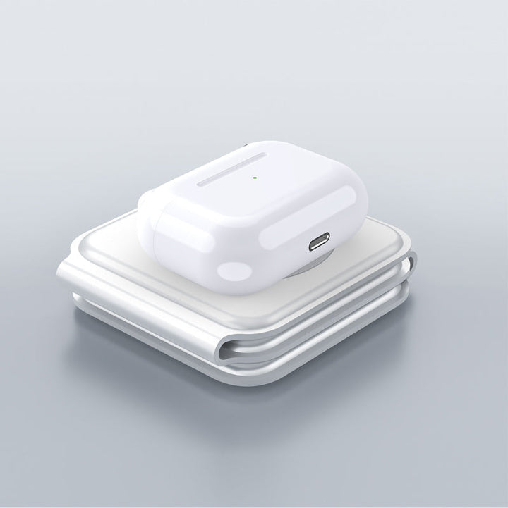 "Vikbar trådlös 3-i-1 laddstation i vit och svart, laddar mobil, AirPods, Apple Watch, sparar plats, stilren design."