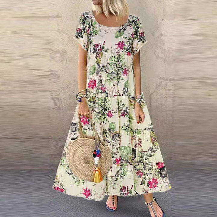 "Vintage damklänning med blommigt mönster, kort och ärmlös, bohemisk stil i blå och rosa toner, perfekt för sommarbruk."