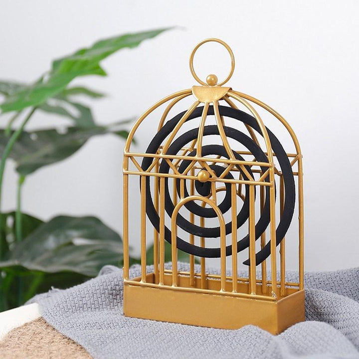 "Vintage myggspolehållare i smidesjärn, fågelbur design, elegant heminredning i gyllene och svart nyans."