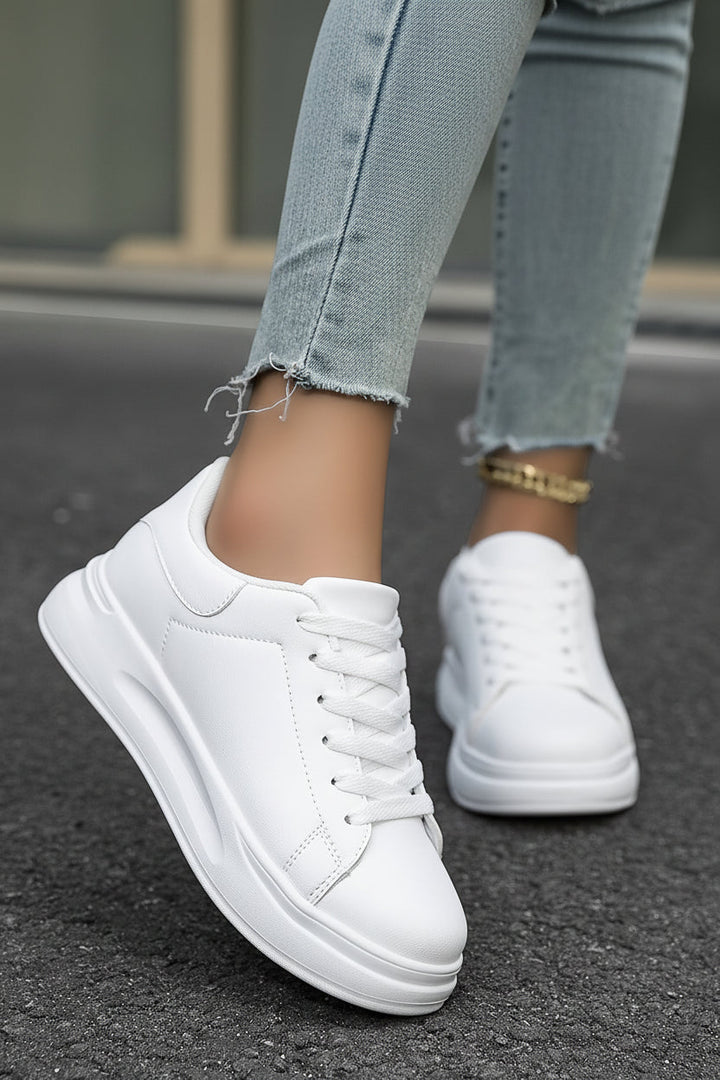 Detaljbild av vit damsneaker "Scarlett". Fokus på material och dämpande sula för bästa komfort.