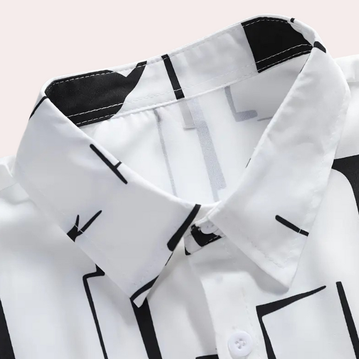 Man bär en stilren, klassisk vit herrskjorta, perfekt för våren. En elegant och bekväm casual-skjorta.