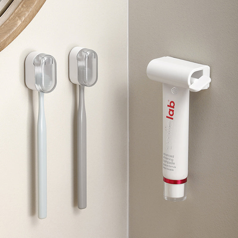 "Vit väggmonterad tandborsthållare i ABS-plast, med lock för hygienisk förvaring, platsbesparande design för små badrum."