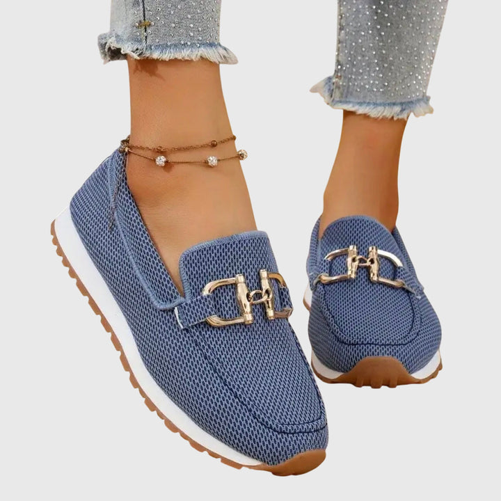 Närbild på bekväma, avslappnade slip-ons för dam i ljus färg med dekorativ söm.