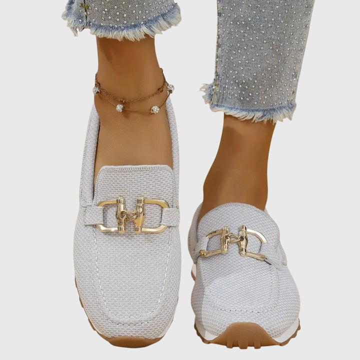 Produkbild på beiga damskor, slip-ons, visande ovandel i textil och sömmar.